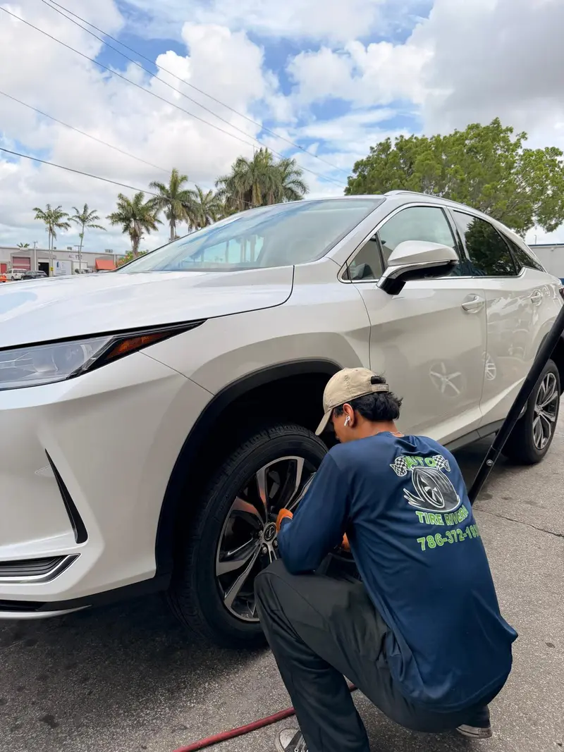 A Rivera tech in the shop shirt working on a customer's Lexus