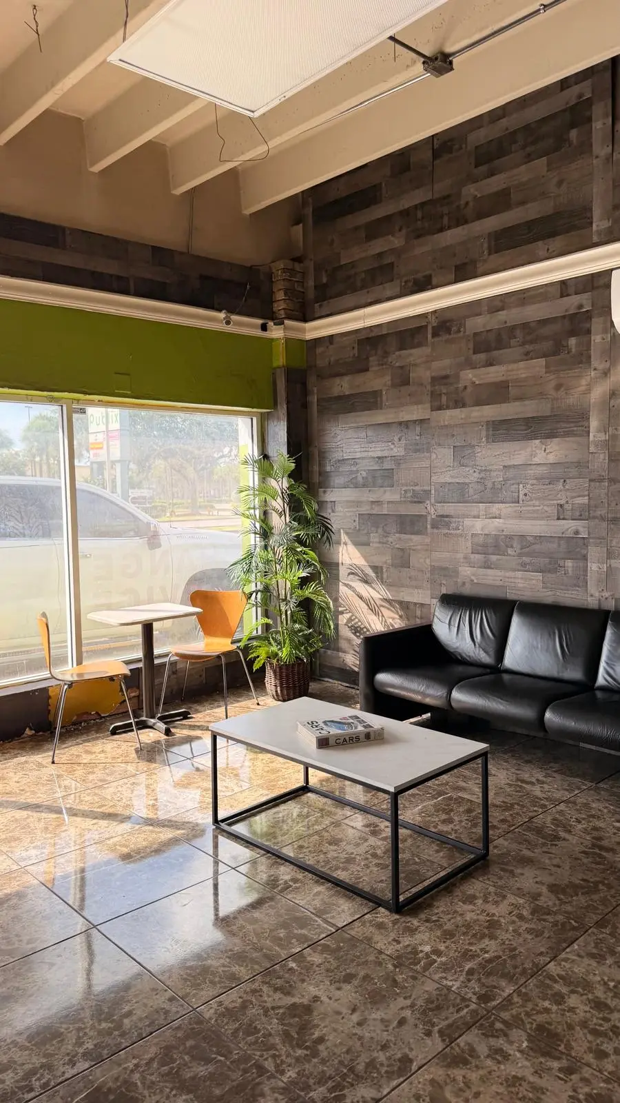 The customer lounge — couch, coffee table and plants