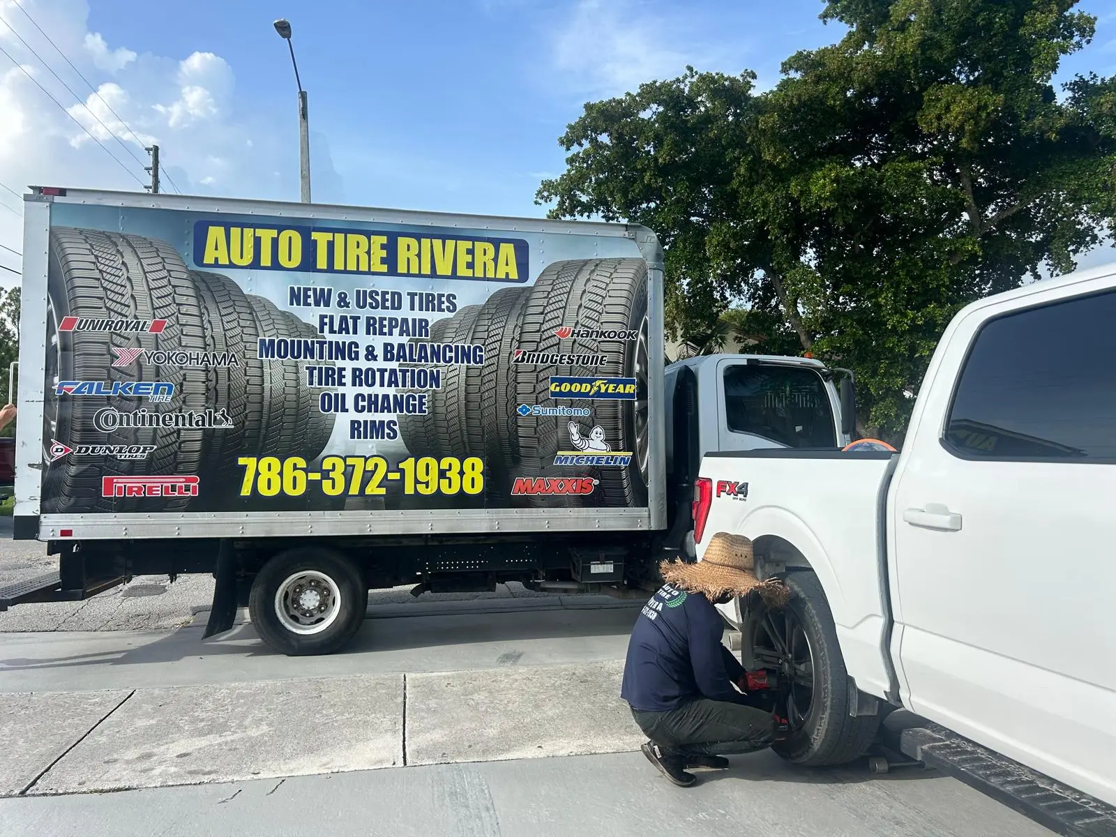 Auto Tire Rivera mobile van on-site while a tech changes a pickup's tire